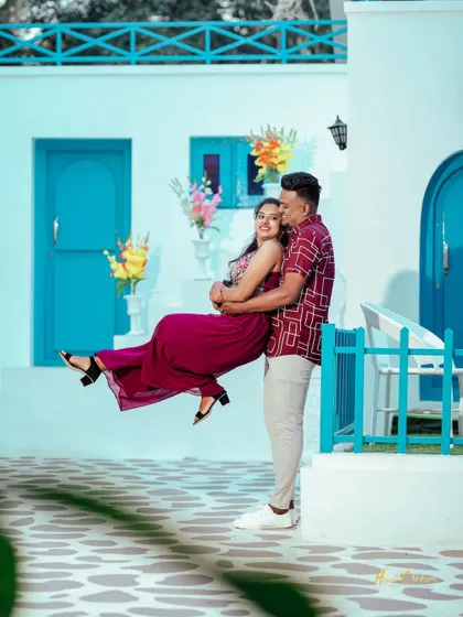 A fun and romantic lift against a backdrop of blue doors and white walls. This playful shot is full of joy and perfectly captures the Santorini theme.