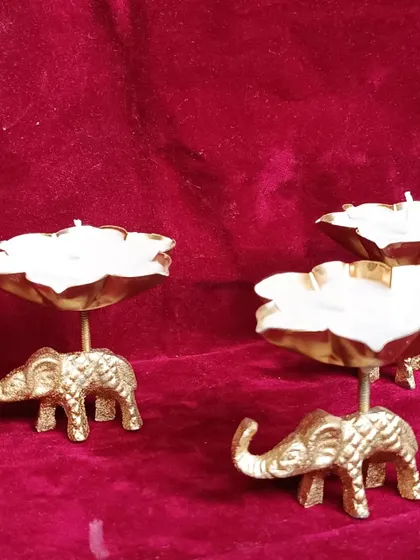 A side view of the elephant urli candle holder, showing the lotus bowl filled with wax.