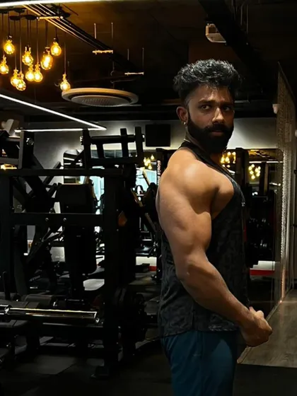 A side pose highlighting the arm and shoulder development. You can see the clear separation between the deltoid, bicep, and tricep muscles.