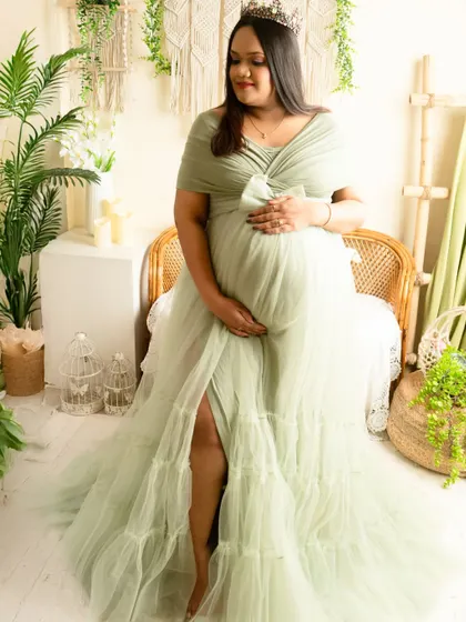 A full-length view of the beautiful tiered green gown. The high slit allows for a pose that is both elegant and confident.
