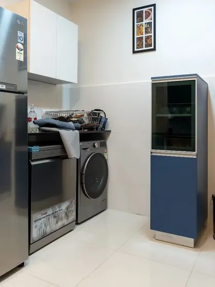 The utility area of the blue kitchen, showing how we can integrate appliances like the washing machine and dishwasher seamlessly into the design.