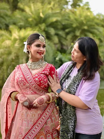 A heartfelt moment between the bride and her makeup artist. The bride is wearing a complete jewellery set from my collection with her red lehenga.