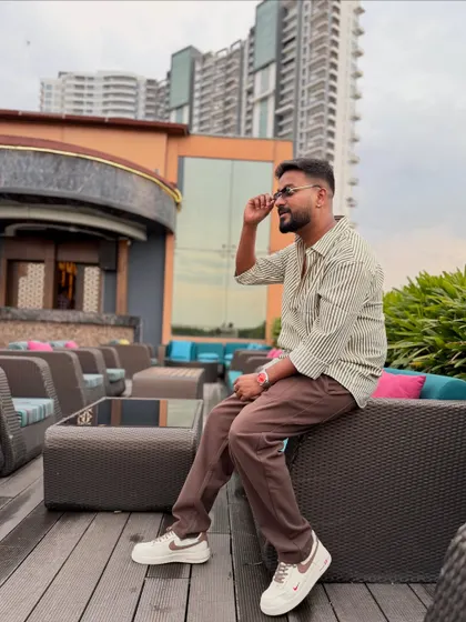 A relaxed moment on a rooftop lounge. This shows a different side of my personality, while still maintaining a cool and fashionable aesthetic.
