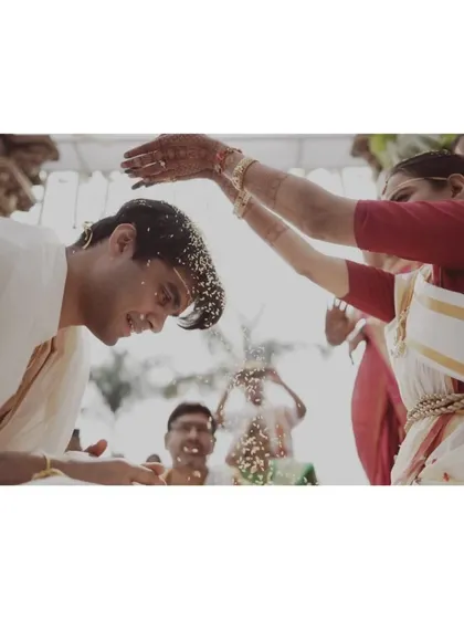 A close-up of the 'talambralu' ritual, where the bride and groom shower each other with rice, pearls, and flowers.