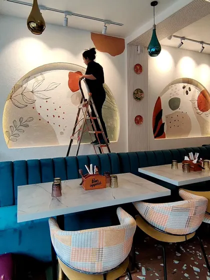 Another action shot of me painting at Cafe Berni, demonstrating the scale of the murals in relation to the seating area.