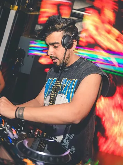 Focused on the mix, with a fiery visual on the screen behind me. I love blending different genres like trap and dubstep into my commercial sets to keep things fresh.