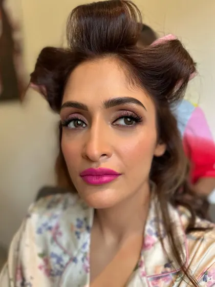 A behind-the-scenes shot of Deepali's Haldi glam in progress. That fuchsia lip color was the perfect choice to brighten up her whole look.