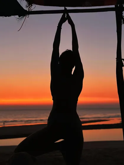 In this silhouette, the focus is on the form of the Tree Pose against the vibrant colors of a Goa sunset. It's a moment of dancing with the shadows, finding stability and grace as the day ends.