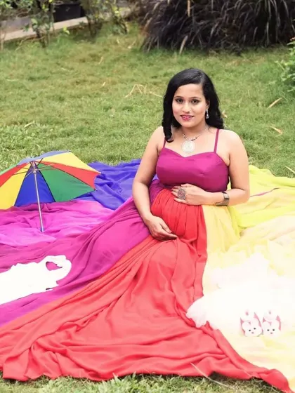 A lovely picnic setup featuring the rainbow maternity gown. The colorful trail is spread out, creating a vibrant and joyful scene with cute baby props.