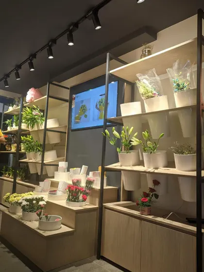 Another shot of the custom display shelves at the FnP store. The combination of natural wood tones and a black metal frame gives the store a modern yet organic feel, perfect for a flower and gift shop.