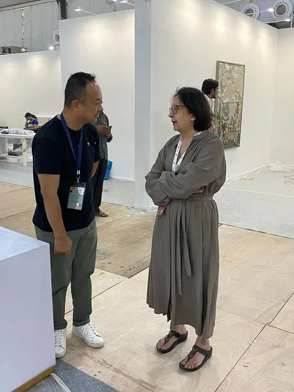 Another shot of the conversation between artist and gallerist amidst the pre-fair chaos.