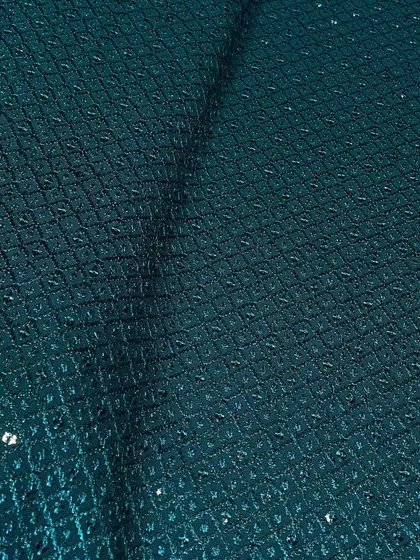 A dark teal green Chikankari fabric. The intricate embroidery and sparse sequin work give it a refined look suitable for formal ethnic wear.