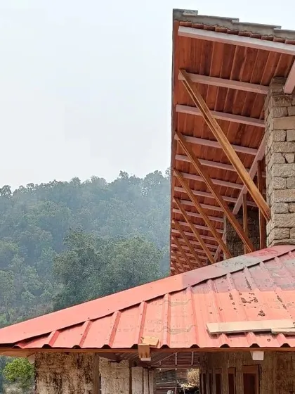 **Haat Market, Shyamlatal:** A detail of the roof structure, showing the wooden trusses and corrugated metal sheeting. This combination of traditional form and modern materials is a practical and cost-effective solution for a community project.