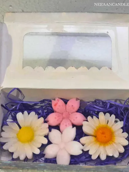 A beautiful gift box of our handmade flower candles. This set includes two daisy candles and two cherry blossom candles, nestled in purple shredded paper.