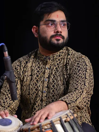 On stage, fully immersed in the performance. The intricate patterns on my kurta mirror the complex rhythms I create on the tabla, weaving a rich tapestry of sound.