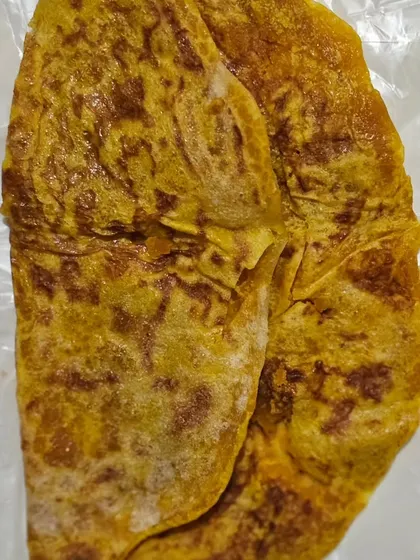 A sweet flatbread, likely a Puran Poli or Obbattu, a traditional dessert served during festivals.