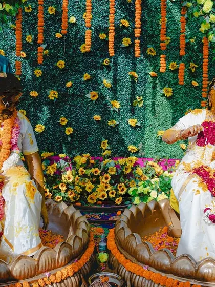 Another angle of the fun-filled Haldi, capturing the bride's laughter as she's covered in turmeric and flower petals.