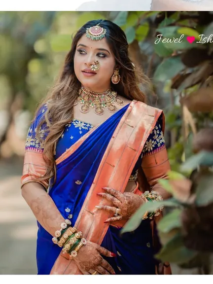 A three-quarter shot of the bride looking graceful and elegant. The combination of the royal blue saree and the gold temple jewellery is a timeless classic for any Marathi bride.