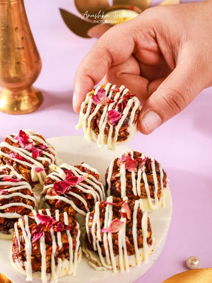 A hand holding one of the mini granola bites, showing its size and tempting texture.