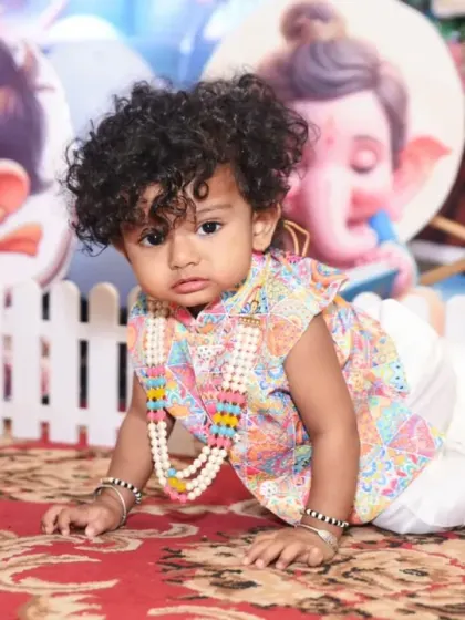 A close-up of the little birthday boy in his traditional outfit, looking absolutely adorable.