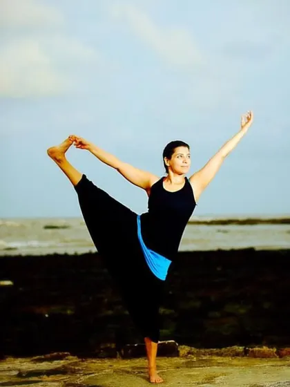 "The world is changed by your example, not by your opinion." A photo of me in a balancing pose by the sea, embodying the principles I teach.
