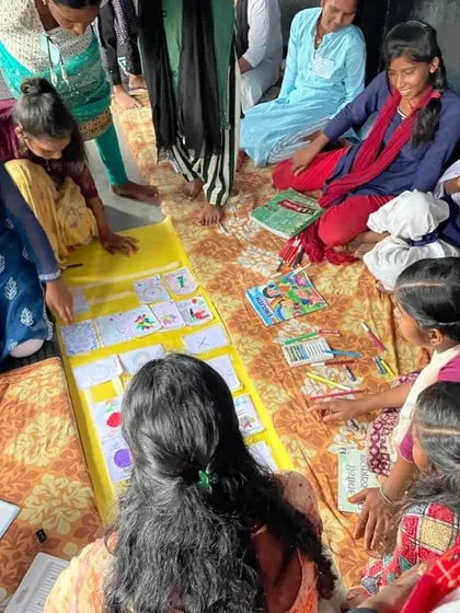 Here, the girls are gathered around a large collaborative piece, looking at the stories and drawings they created together. This was a powerful moment of seeing their individual contributions come together to form a collective narrative.