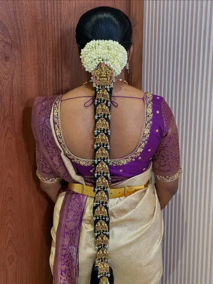 A truly regal bridal look featuring a full set of gold temple jewellery along the entire length of the braid. The jasmine veni at the top completes this classic Muhurtham hairstyle.