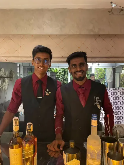 Our bartenders in matching red and black uniforms, ready to serve at a birthday party. We bring the same level of professionalism to private parties as we do to large weddings.