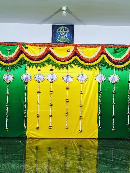 A simple and classic backdrop for a naming ceremony. The design uses yellow and green drapes with a floral valance and hanging elements ready for the name reveal.