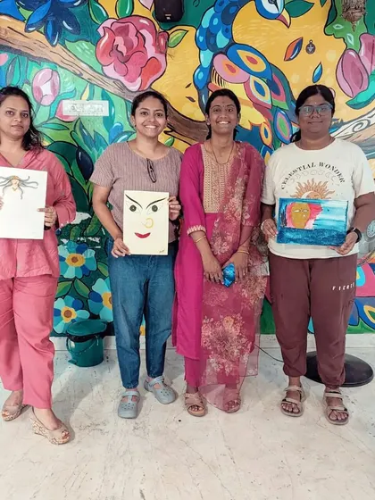 The proud artists of the "Awakening Shakti" workshop, holding up their expressive and powerful paintings.