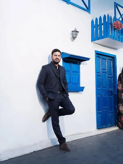 A stylish and modern portrait against the clean lines of the Santorini-themed architecture. This shot has a cool, editorial feel.
