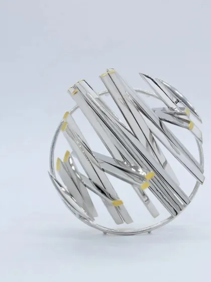 An example of the intricate, abstract designs you can create with silver. This beautiful brooch was crafted by our workshop mentor, showcasing advanced silversmithing techniques.