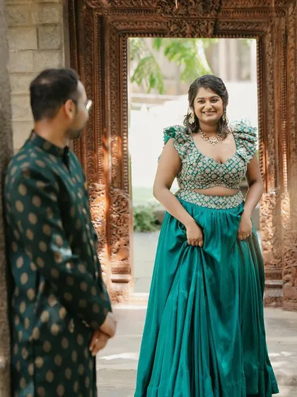 A beautiful shot of the bride and groom, with him looking on as she poses in her gorgeous Mehendi outfit.