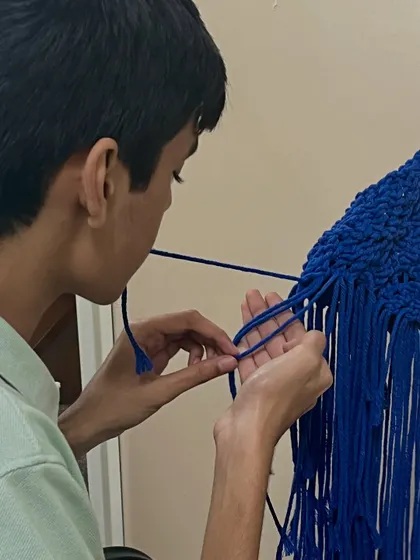 This student is using an adaptive technique, holding a cord with his mouth to free up his hands. We always find ways to make sure every student can participate fully and successfully.