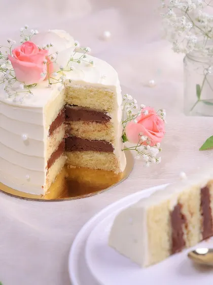 We believe that simple gestures are the most profound. This happy anniversary cake features a clean, white-frosted design, elegantly adorned with fresh pink and white roses, baby's breath, and delicate pearls for a look of pure and simple romance.