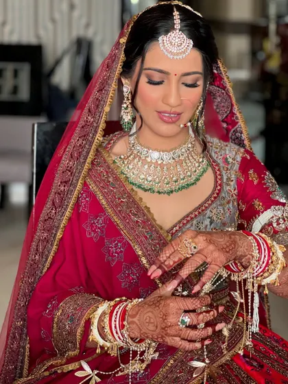 The final touches for Priya's look. Her intricate jewelry and the soft, dewy makeup came together to create a truly memorable and elegant bridal style.