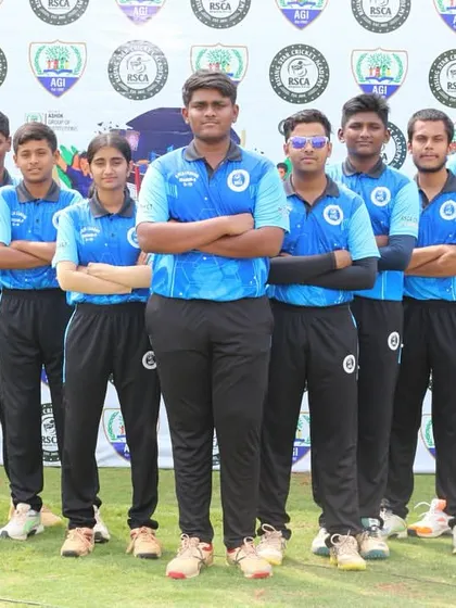 A team in blue jerseys poses with arms crossed, showing confidence and unity.