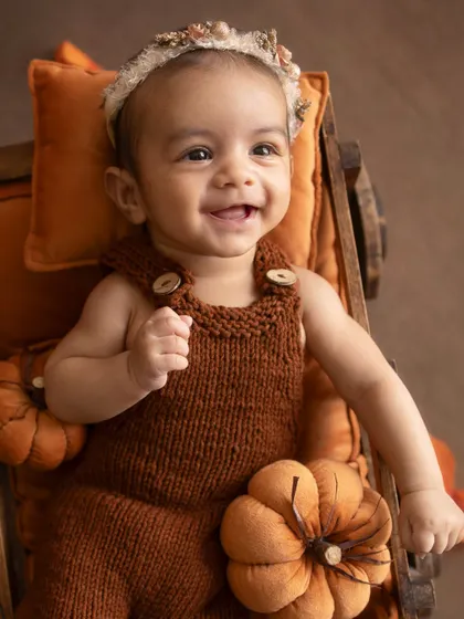 Pure happiness. This baby's joyful expression is the highlight of her autumn-themed milestone session.