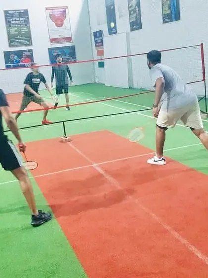 Players getting low and ready for a defensive shot in a competitive doubles rally.
