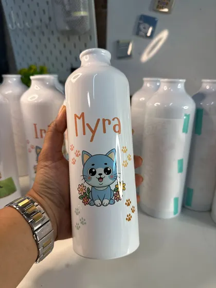 How adorable is this personalized bottle with a cute cat design and the name 'Myra'? Perfect for kids' return gifts.
