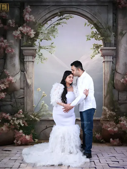 A fairytale moment for the couple. Dressed in white, they share a tender moment in one of our elaborate floral studio sets.
