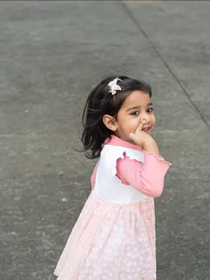 A shy glance back from a little girl during a walk. I capture these fleeting, authentic moments that define childhood.