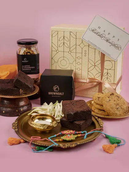 A luxurious Rakhi hamper filled with brownies, granola, and cookies. We style these shots to look abundant and desirable, perfect for promoting festive gift sets.