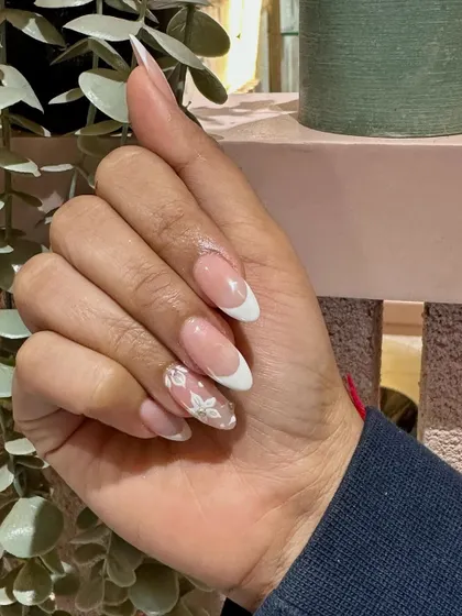A close-up on the delicate, hand-painted flower that elevates this French manicure from classic to custom.
