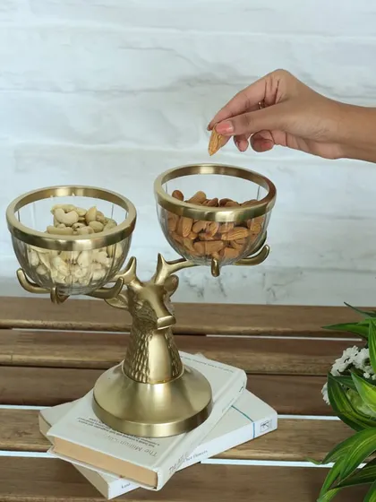 Our golden reindeer stand, shown here holding glass bowls filled with nuts. It's a functional work of art, designed to bring a touch of enchantment to your hosting essentials.