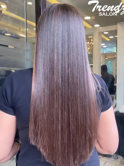 Sleek, straight, and stunning. This photo showcases a global color application that resulted in incredibly shiny and healthy-looking hair.