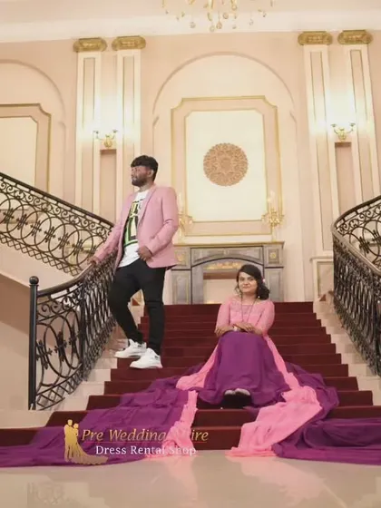 A great example of a bold, coordinated look. The groom's pink blazer picks up the lighter tones in the bride's dual-color purple and pink flying gown, tying the two distinct outfits together seamlessly.