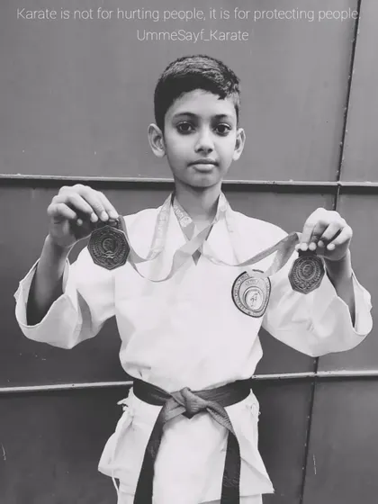 "Karate is not for hurting people, it is for protecting people." This student, holding his tournament medals, understands the true meaning of martial arts.