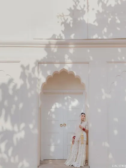 Using architecture to frame a bridal portrait. The clean white walls and the shadows of the leaves create a beautiful, high-contrast backdrop for Sejal's elegant pose, making it a simple yet striking image.