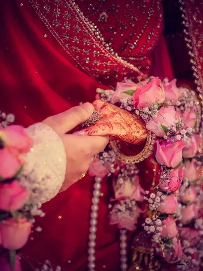 A close-up shot focusing on the couple holding hands, a simple yet powerful symbol of their union.